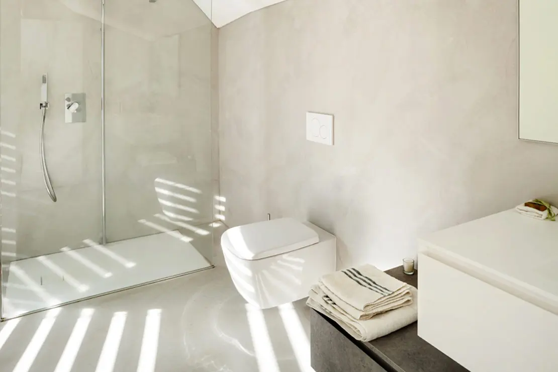 Baño con suelo y paredes de microcemento en tonalidad clara Baño con suelo y paredes de microcemento en tonalidad clara